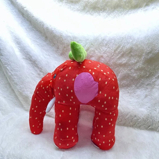 Red strawberry-shaped plush toy with a pink center on a white blanket