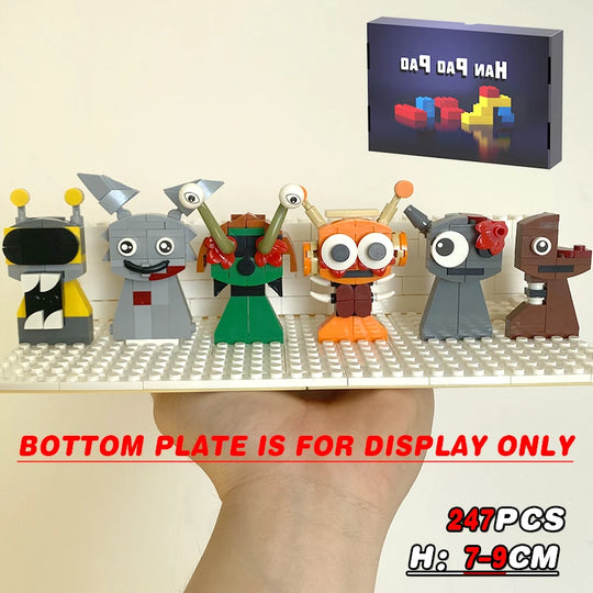 Set of colorful robot toy figures on a display base with a small screen in the background.