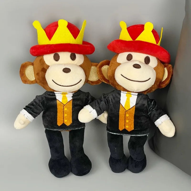 Two plush monkey toys wearing suits and crowns on a gray background
