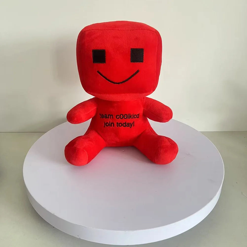 Red plush toy with a smiley face on a white platform