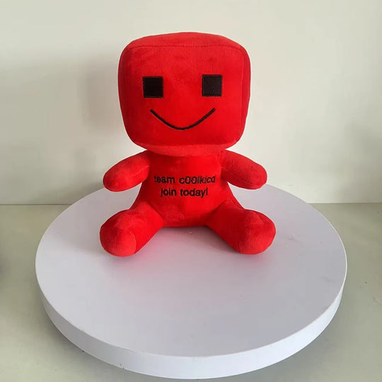Red plush toy with a smiley face on a white platform