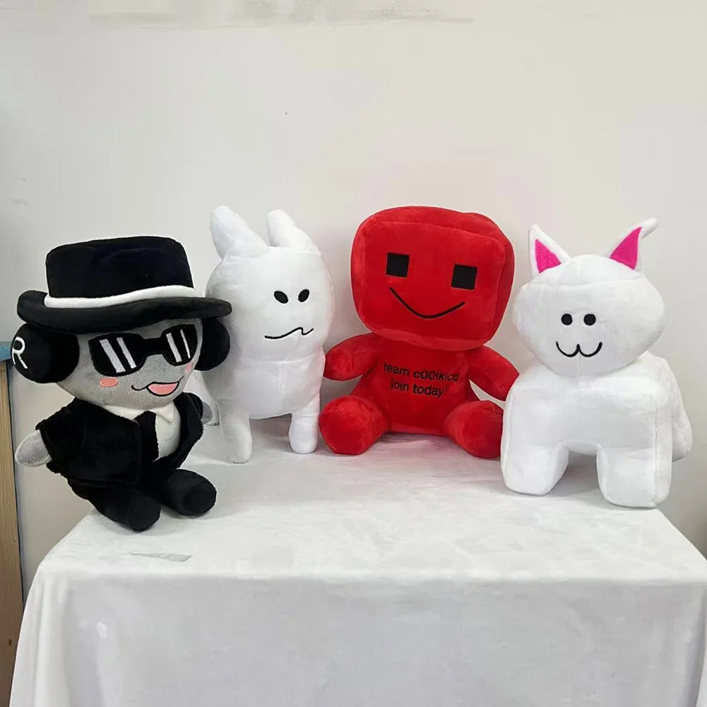 Four plush toys on a white tablecloth with a plain background
